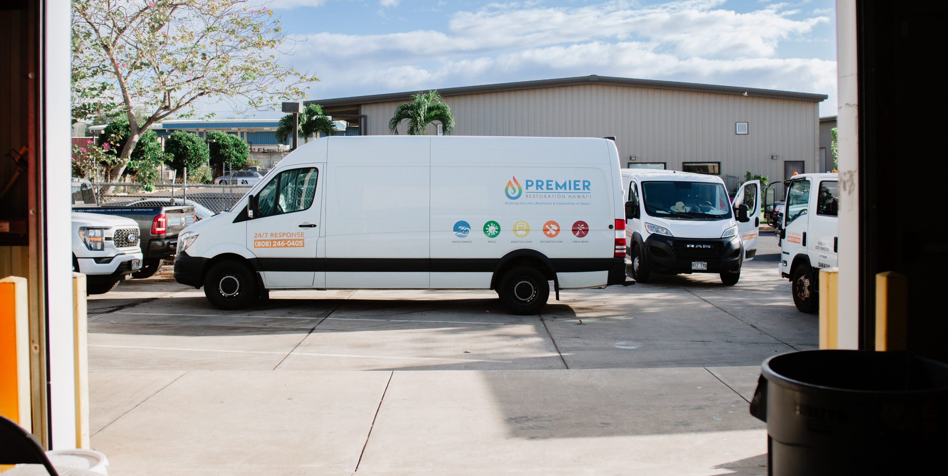 Premier Restoration Hawaii van parked outside a facility with blue skies.