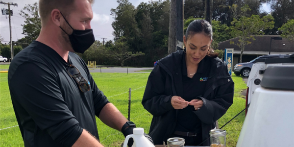 Two people conducting outdoor scientific research with soil and equipment.