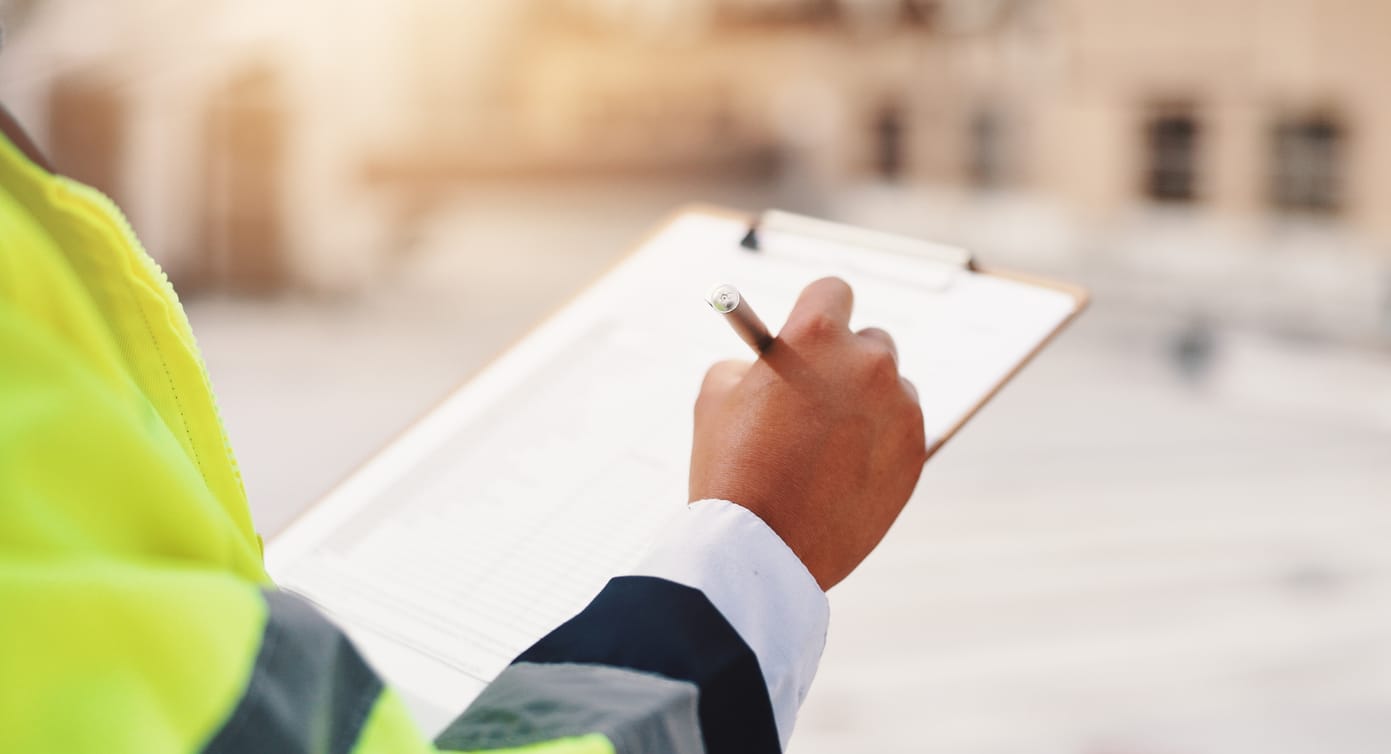 A property manager in a high-visibility jacket reviewing their Hawaii hurricane prep checklist.